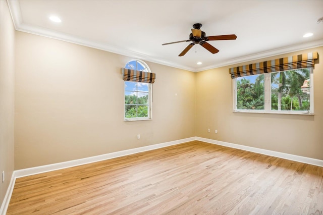 empty room with a wealth of natural light, light hardwood / wood-style flooring, ceiling fan, and ornamental molding