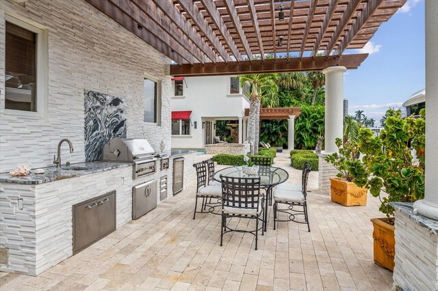 view of patio / terrace with exterior kitchen, area for grilling, a pergola, and sink