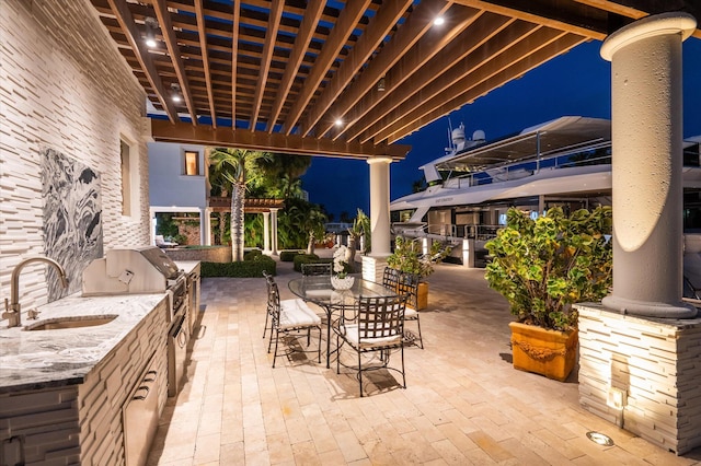 patio at twilight featuring a pergola, area for grilling, and sink