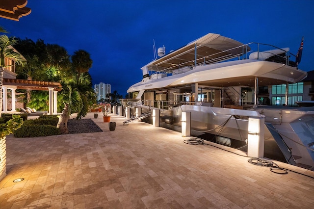 patio at twilight with a balcony and a pergola