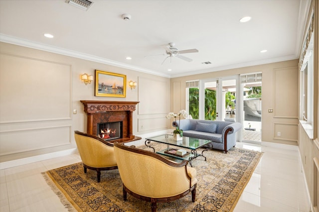 living room featuring a high end fireplace, crown molding, ceiling fan, and light tile patterned floors