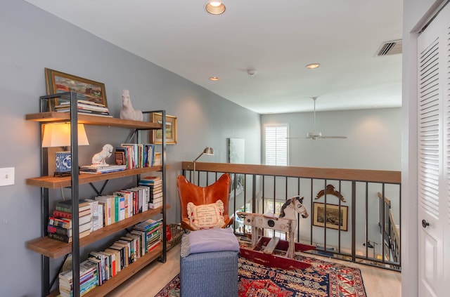 living area with light hardwood / wood-style flooring and ceiling fan