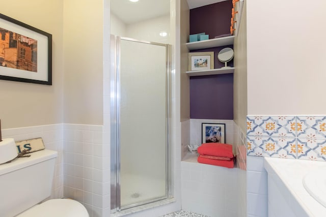 bathroom featuring tile walls, an enclosed shower, and toilet