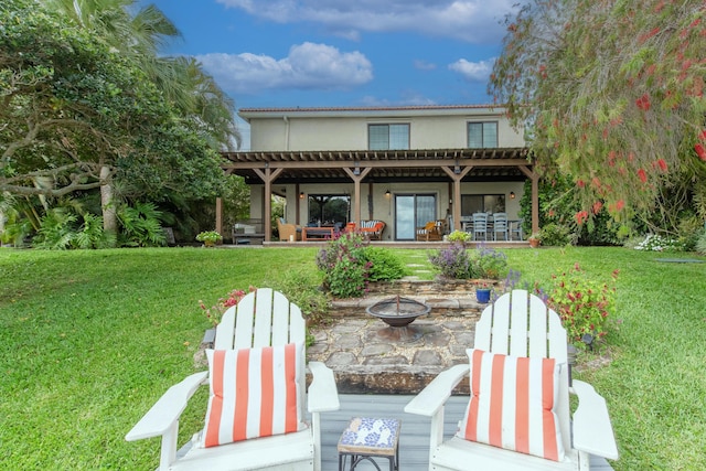 rear view of property with an outdoor living space with a fire pit, a patio, a pergola, and a yard