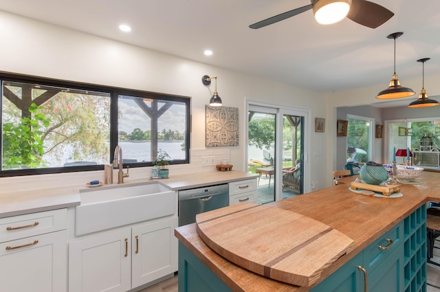 kitchen featuring hanging light fixtures, plenty of natural light, sink, and dishwasher