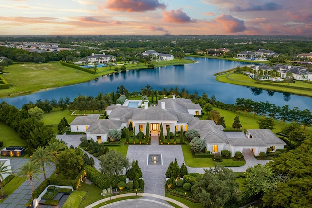 aerial view at dusk featuring a water view