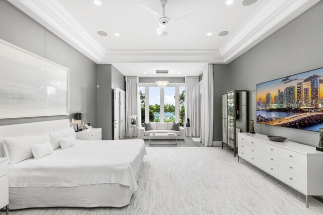 bedroom featuring crown molding, light colored carpet, ceiling fan with notable chandelier, and a raised ceiling