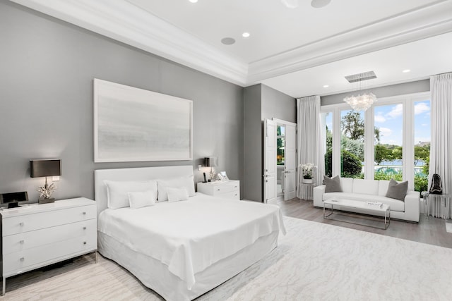 bedroom featuring an inviting chandelier, light wood-type flooring, and crown molding