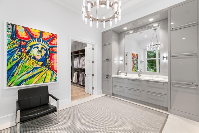 bathroom with vanity, a notable chandelier, ornamental molding, and wood-type flooring