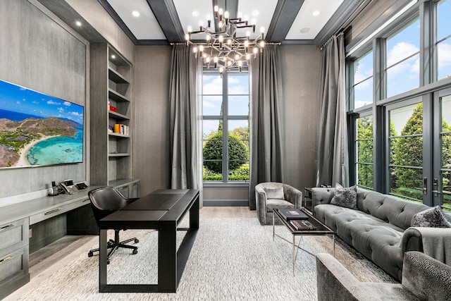 home office featuring built in desk, beamed ceiling, a chandelier, light wood-type flooring, and built in shelves