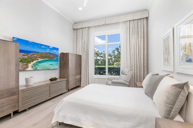 bedroom with light hardwood / wood-style flooring and ornamental molding