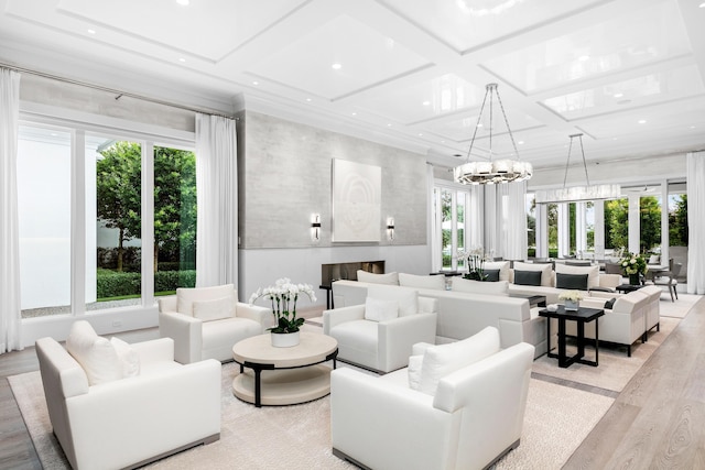 living room featuring coffered ceiling, light hardwood / wood-style floors, and a chandelier