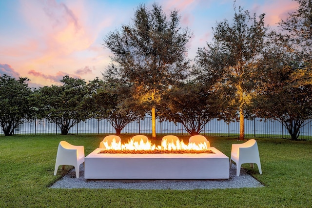 view of home's community featuring a lawn and a fire pit