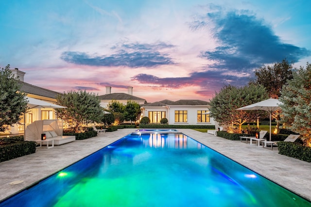 pool at dusk with a patio