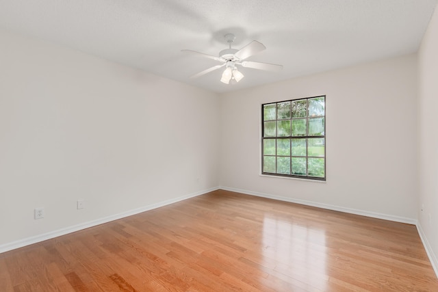 empty room with light hardwood / wood-style flooring and ceiling fan