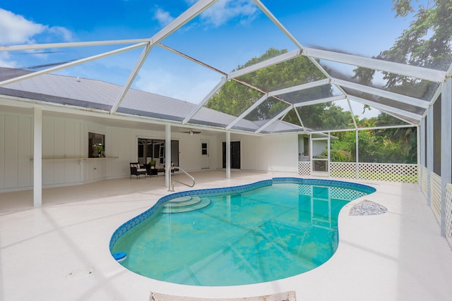 view of swimming pool with glass enclosure, a patio area, and ceiling fan