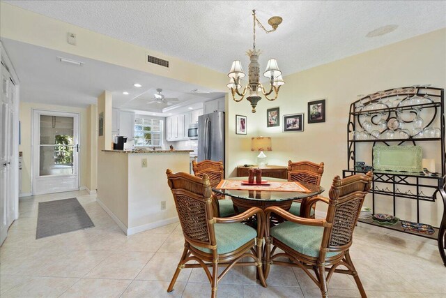 tiled dining room featuring a tray ceiling, an inviting chandelier, and a textured ceiling