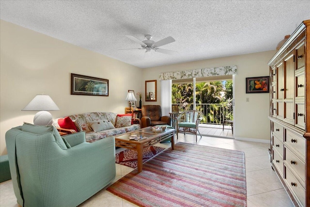 living room with light tile patterned floors, a ceiling fan, baseboards, and a textured ceiling