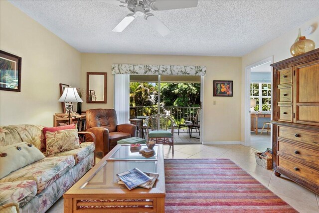 tiled living room featuring a textured ceiling, a healthy amount of sunlight, and ceiling fan