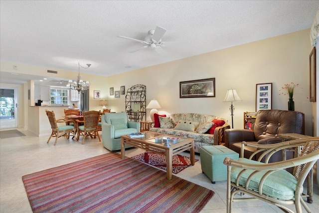 living area with light tile patterned floors, visible vents, a textured ceiling, and ceiling fan with notable chandelier