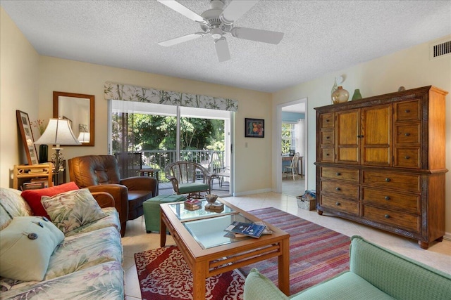 living room with light tile patterned floors, baseboards, a textured ceiling, and a ceiling fan