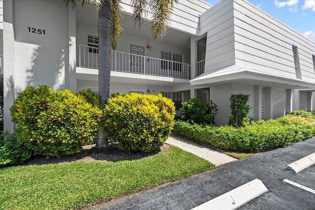 view of side of property featuring a balcony and stucco siding