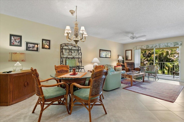 dining space featuring a textured ceiling, light tile patterned flooring, and ceiling fan with notable chandelier