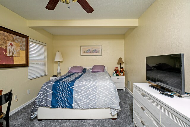 bedroom with ceiling fan, a textured ceiling, and dark colored carpet