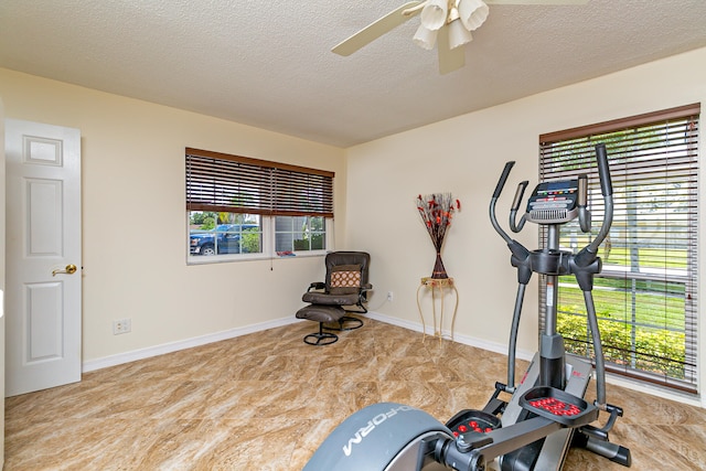 workout area featuring a textured ceiling and ceiling fan