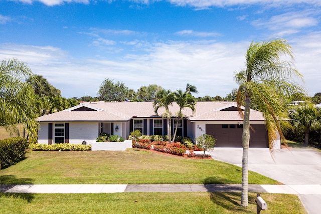 single story home with a garage and a front lawn