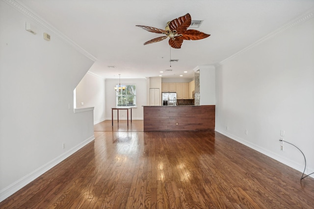 unfurnished living room with ceiling fan with notable chandelier, crown molding, and dark wood-type flooring