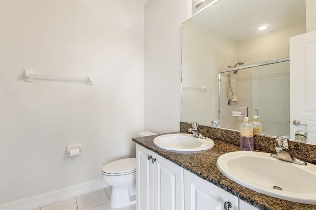 bathroom featuring tile patterned floors, vanity, a shower with shower door, and toilet