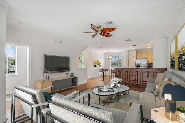 living room featuring light hardwood / wood-style floors, plenty of natural light, and crown molding