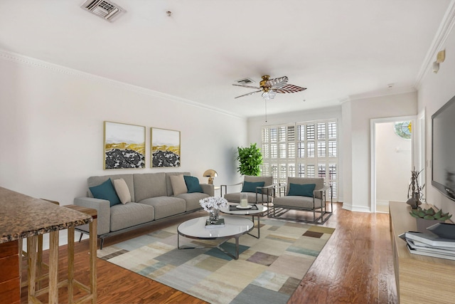 living room with light hardwood / wood-style floors, ceiling fan, and ornamental molding