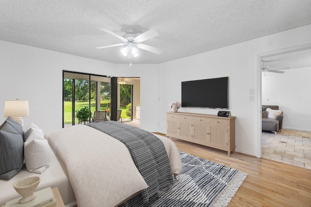 bedroom featuring a textured ceiling, access to exterior, ceiling fan, and light hardwood / wood-style floors