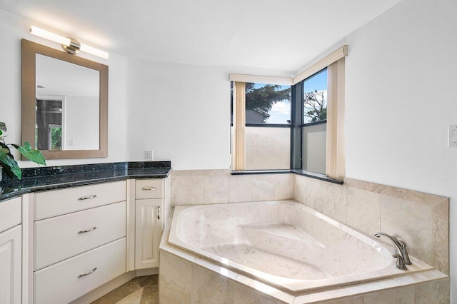 bathroom with vanity and tiled tub