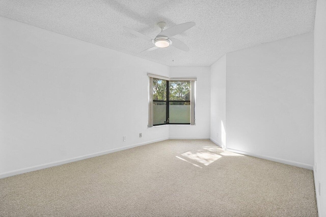 spare room with a textured ceiling, ceiling fan, and carpet