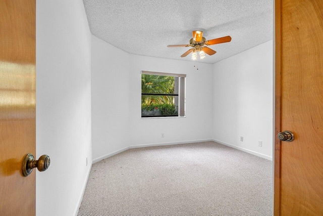 spare room featuring a textured ceiling, ceiling fan, and carpet