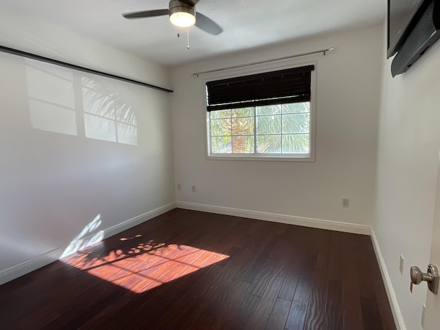 empty room featuring ceiling fan and dark hardwood / wood-style flooring