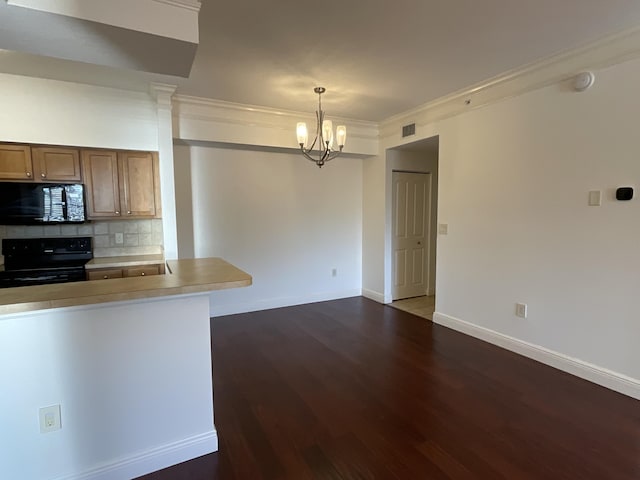 kitchen with hanging light fixtures, black appliances, decorative backsplash, an inviting chandelier, and crown molding