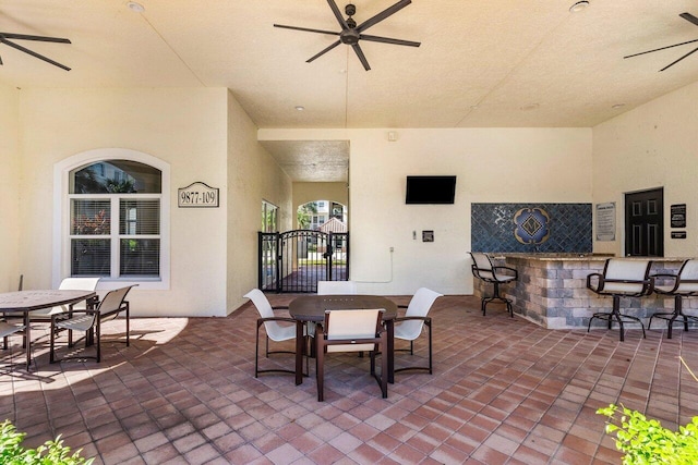 view of patio featuring exterior bar and ceiling fan