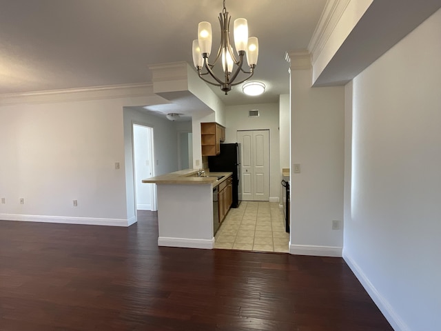 kitchen featuring light hardwood / wood-style floors, kitchen peninsula, ornamental molding, a notable chandelier, and decorative light fixtures