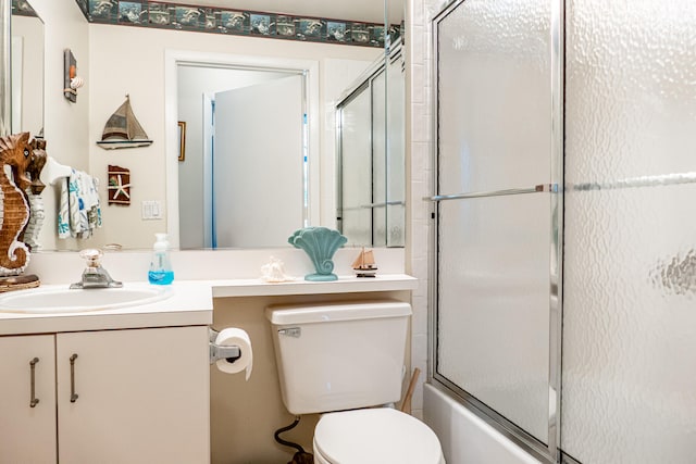 full bathroom featuring enclosed tub / shower combo, vanity, and toilet