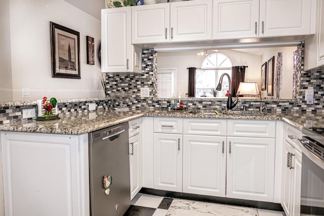 kitchen with stone countertops, white cabinetry, sink, decorative backsplash, and stainless steel appliances