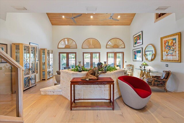 living room featuring high vaulted ceiling, wood ceiling, a wealth of natural light, and light hardwood / wood-style floors