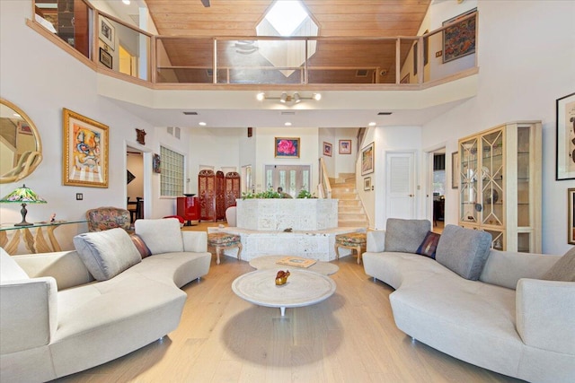 living room with a high ceiling, hardwood / wood-style flooring, and wood ceiling