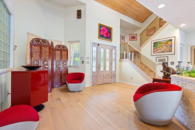 foyer with wood ceiling, a towering ceiling, and hardwood / wood-style flooring