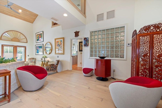 living area featuring high vaulted ceiling and light hardwood / wood-style floors