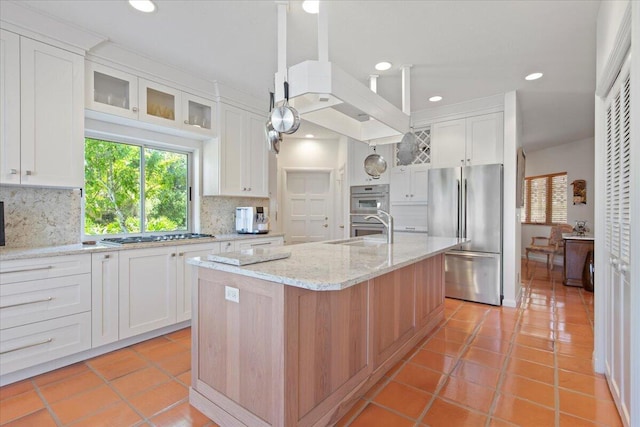 kitchen with white cabinetry, appliances with stainless steel finishes, sink, and a center island with sink