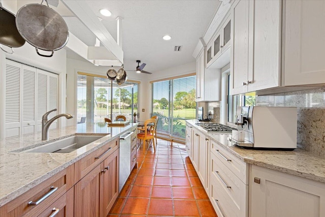 kitchen featuring white cabinetry, sink, backsplash, and dishwasher